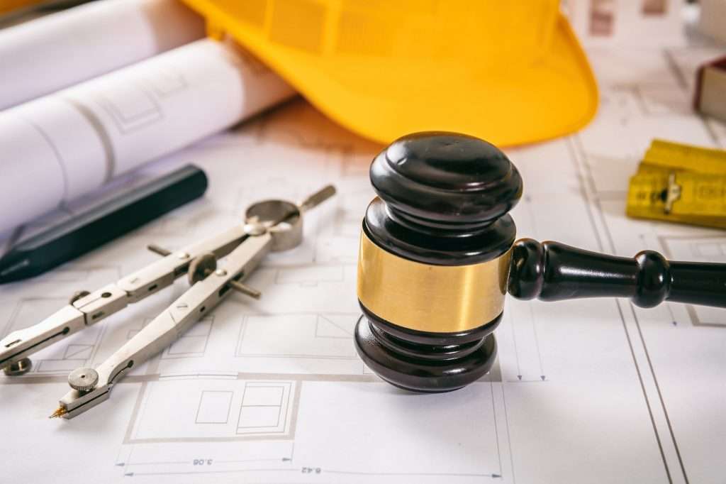 Construction and Labor law. Judge gavel and design tools on building blueprint, close up